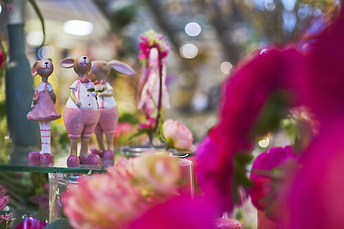 Frühlingshafte Hasenfiguren in Rosa mit floraler Deko und bunten Blumen bei JOSKA.