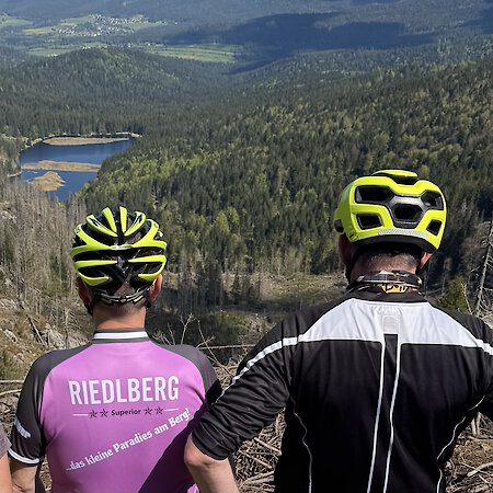 Zwei E-Biker am großen Arber mit Blick auf den kleinen Arbersee